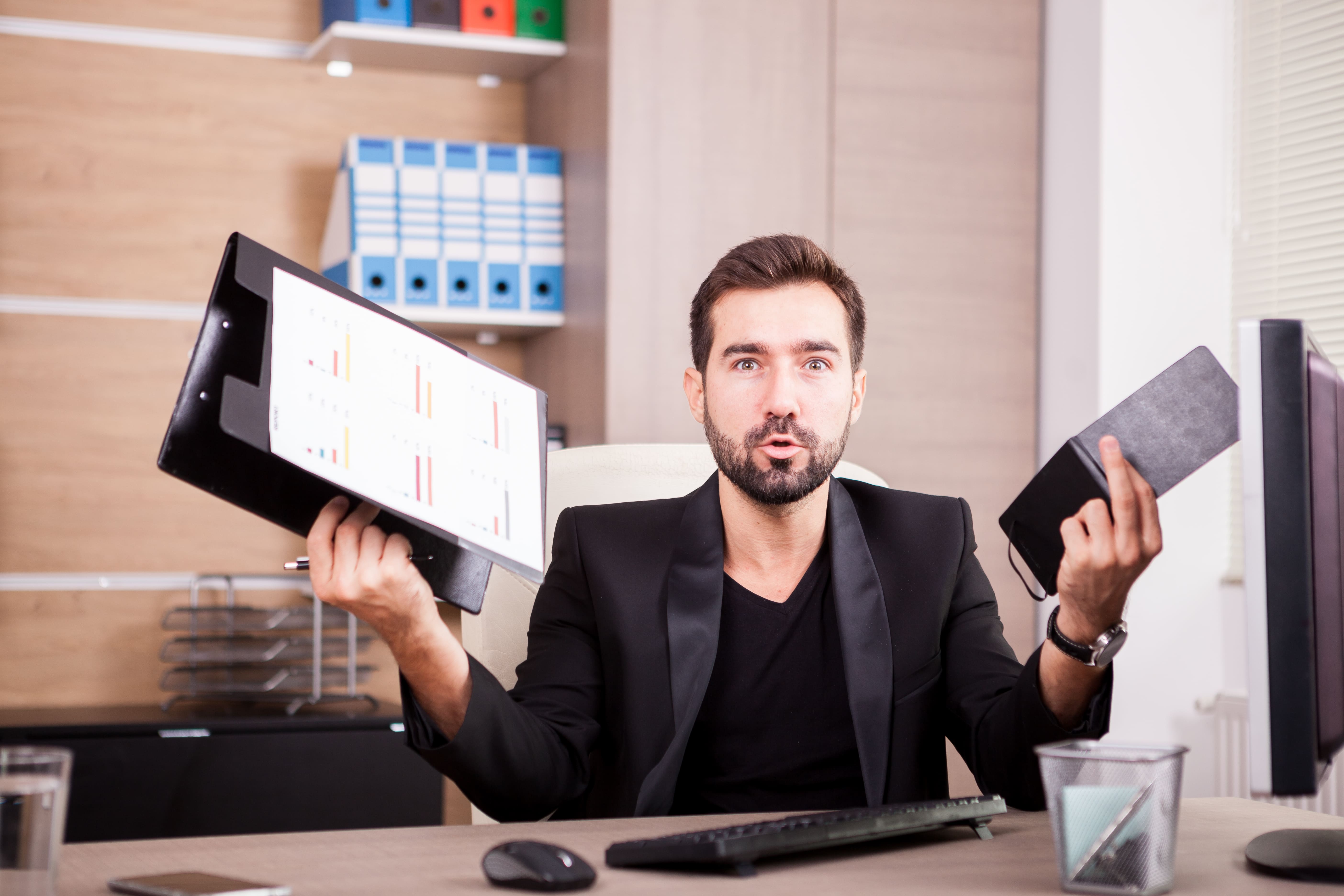 Business professional reviewing payroll reports and office documents